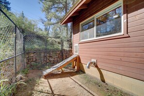 A wooden cabin with a window, a wooden ramp, and a chain-link fence. - Cozy Prescott Cabin, Surrounded By Ponderosa Pines (Prescott)