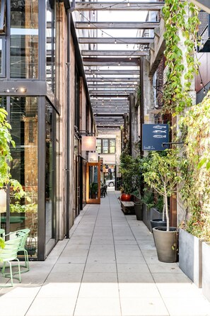An indoor corridor with a modern design, featuring a glass storefront on the left and a signboard on the right. - Loft Apartment Cali King Peloton Walkable (Seattle)