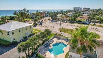 Un resort con piscina, palmeras y vistas al océano.