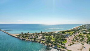 A coastal resort with a beachfront, palm trees, and a marina. - Closest to Jetty Park — Pool & Sundeck, 24/7 Staff, Front & Back Decks · Unit D (Fort Pierce)