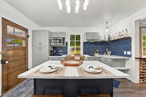 A modern kitchen with a central island, built-in appliances, and a wine rack. - Walter-Jenschke Sunday House - Bumper Pool Table (Fredericksburg)