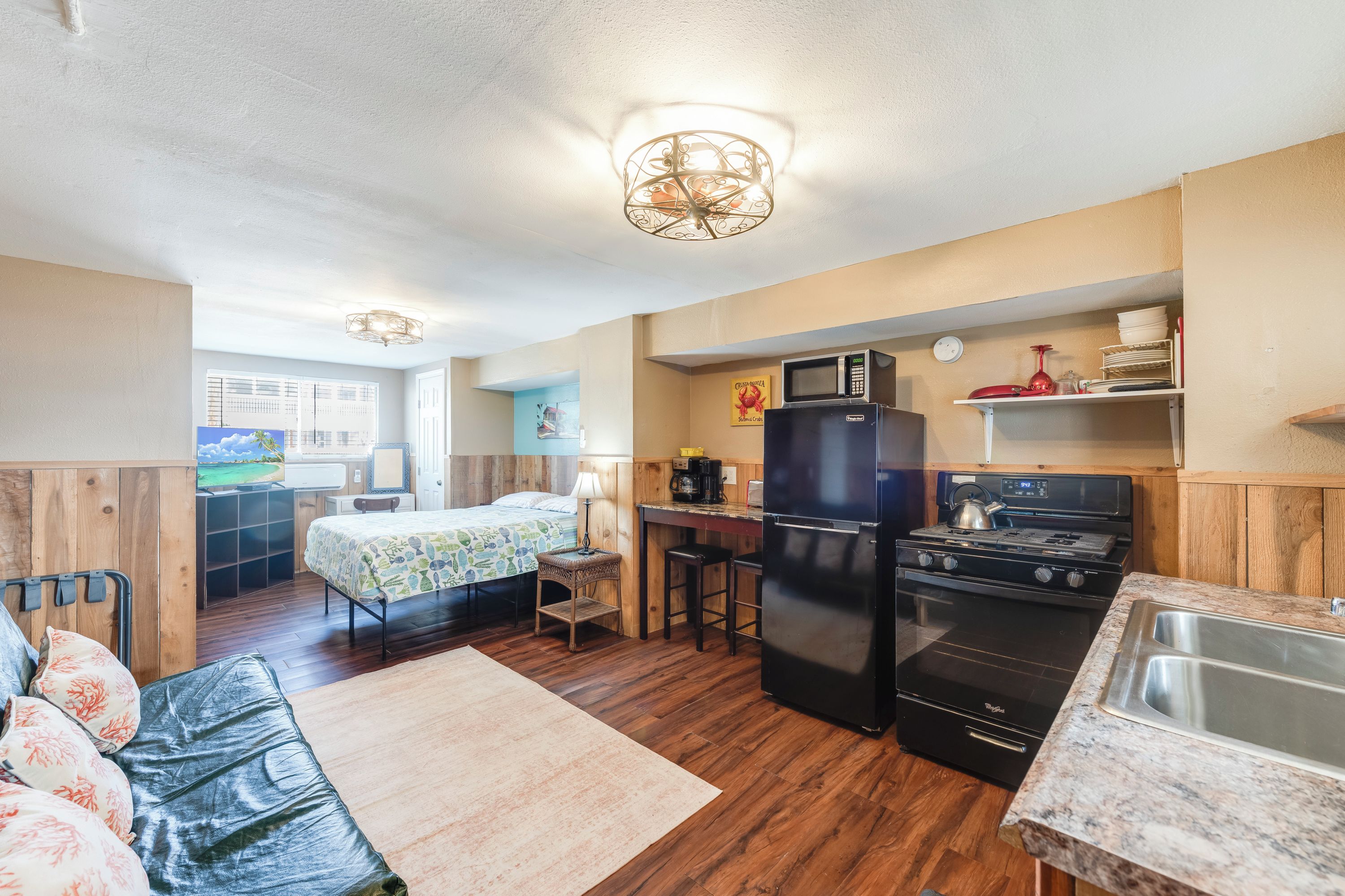 A compact kitchen with a refrigerator, stove, and microwave.