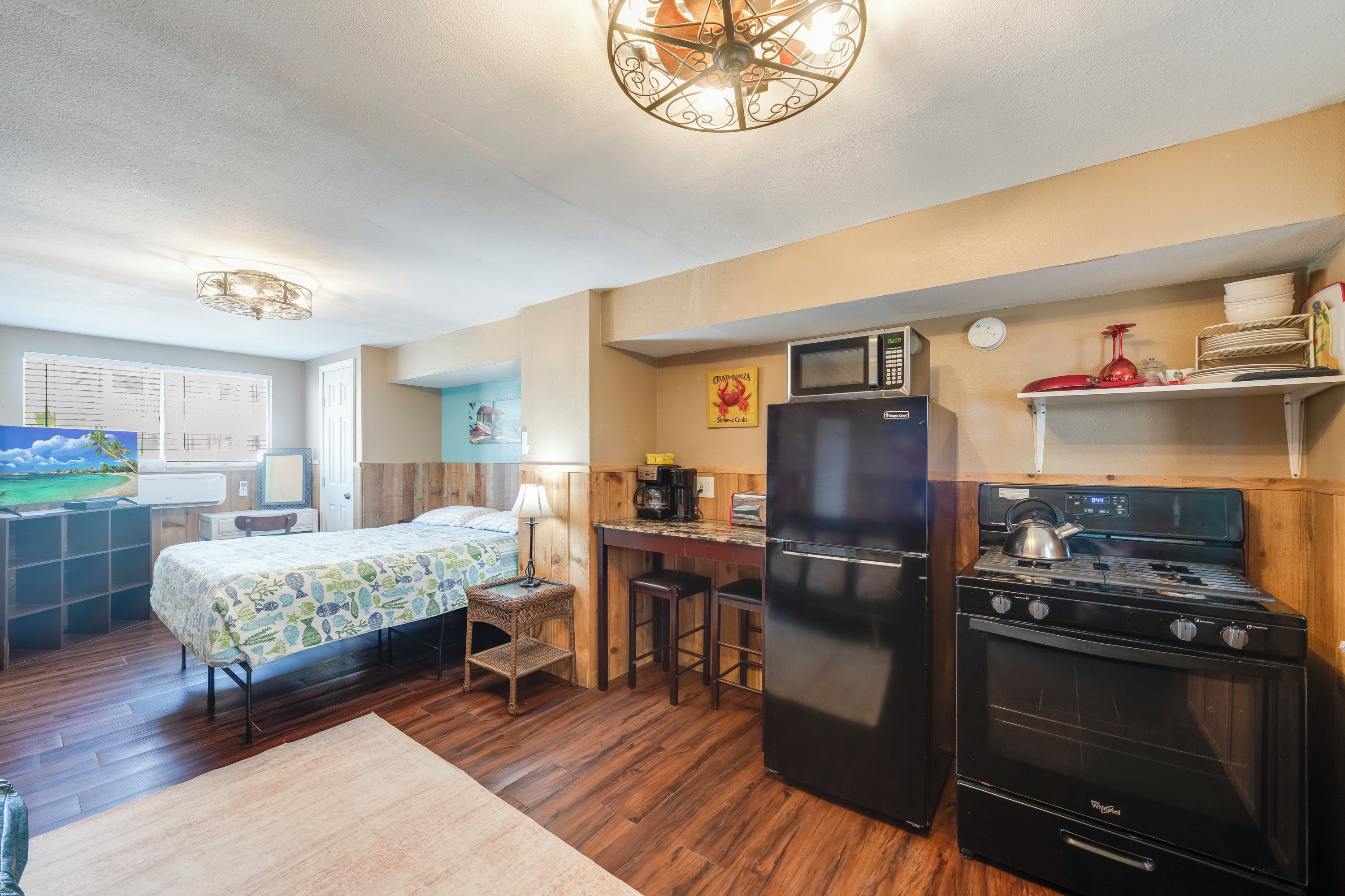 A compact kitchen with a refrigerator, microwave, and stove.