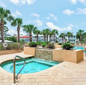 A swimming pool area with a hot tub, palm trees, and a view of resort buildings. - HIGH TIDE - SUN, SAND & SOUTHERN CHARM
CANAL FRONT- BOAT DOCK- POOL (Mexico Beach)