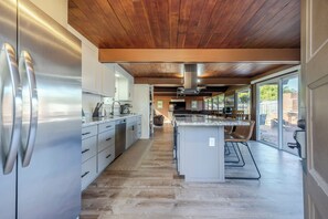 A modern kitchen with a central island, stainless steel appliances, and a wooden ceiling. - New Listing in Eugene's highly sought after "Ferry Street Bridge" neighborhood. (Eugene)