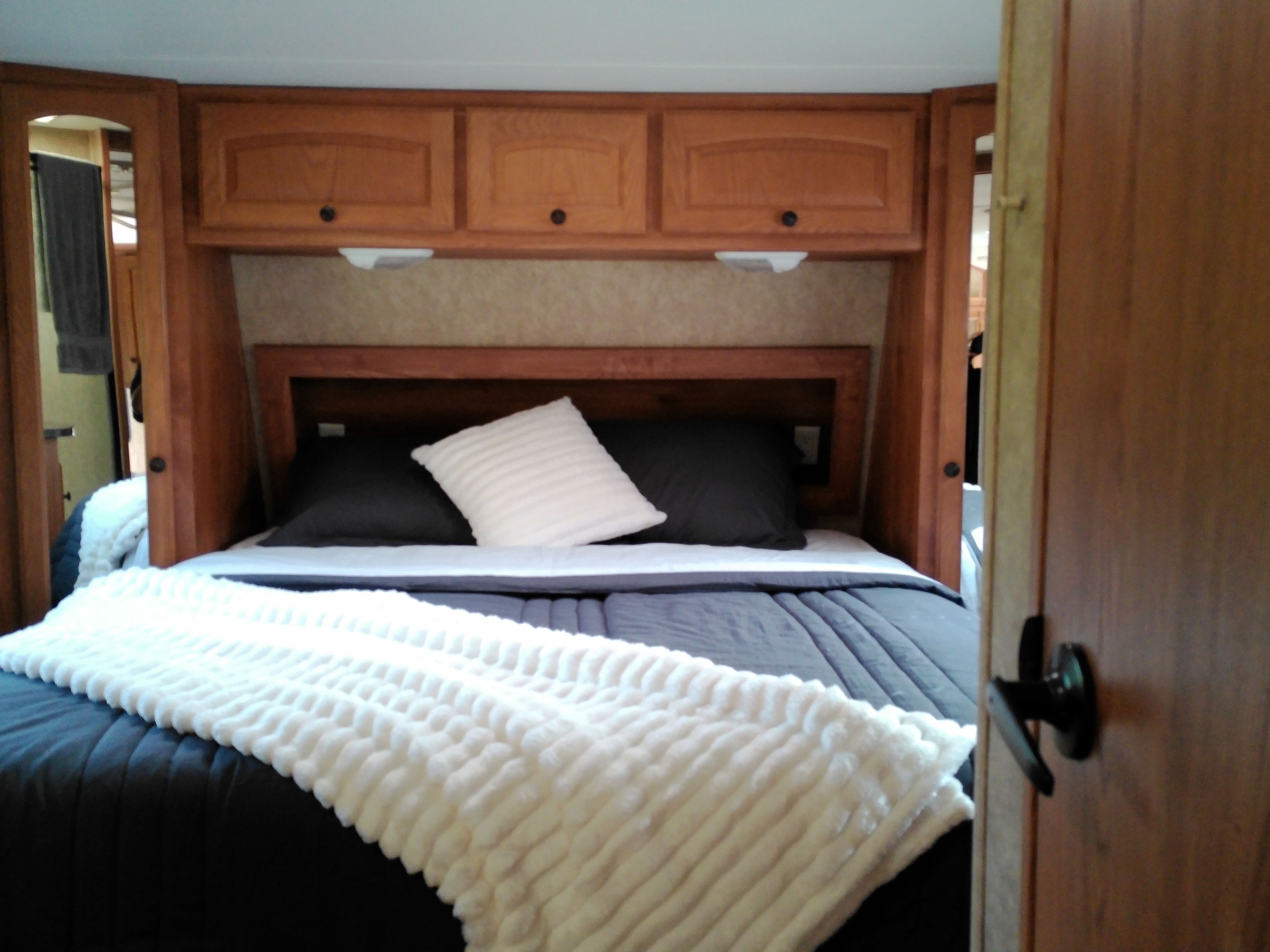 Ein Schlafzimmer mit einem Bett, einem Holzkopfstück und einer Tür.