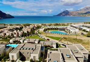 Ein Küstenort mit mehreren Gebäuden, einem Schwimmbad und Blick aufs Meer.