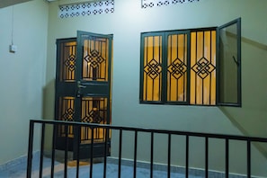 A room with a balcony, a door with decorative glass panels, and a window with similar panels. - Bethel Residence; Private 1-bedroom home in Kampala-free WiFI, Netflix, parking (Kampala)