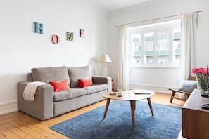 A modern living room with a grey sofa, a round coffee table, and a blue rug. - Casa da Avenida IV Lisboa (Lisbon)