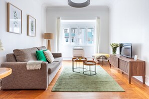 A modern living room with a sofa, coffee table, and TV. - Casa da Avenida II Lisboa (Lisbon)