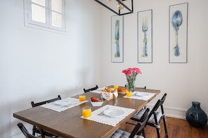 A dining table set with plates, cutlery, and a vase of flowers. - Casa da Avenida II Lisboa (Lisbon)