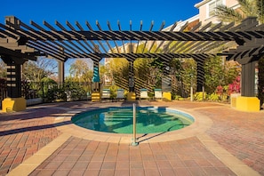 A circular pool with a pergola overhead, surrounded by a brick patio and a fence. - Spacious 3BR condo, Perfect Orlando Home Base (Orlando)