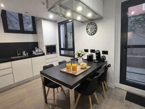 A modern kitchen with a dining table, chairs, a clock, and a coffee maker. - Private Room in Apartment, Madrid (Madrid)