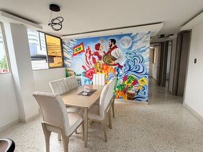 A dining area with a mural, a table, and chairs. - Cozy 3-bedroom en La Zona Rosa de Barranquilla (Barranquilla)
