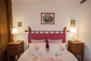 Una camera da letto con un letto, due comodini, una testiera e due lampade a parete.