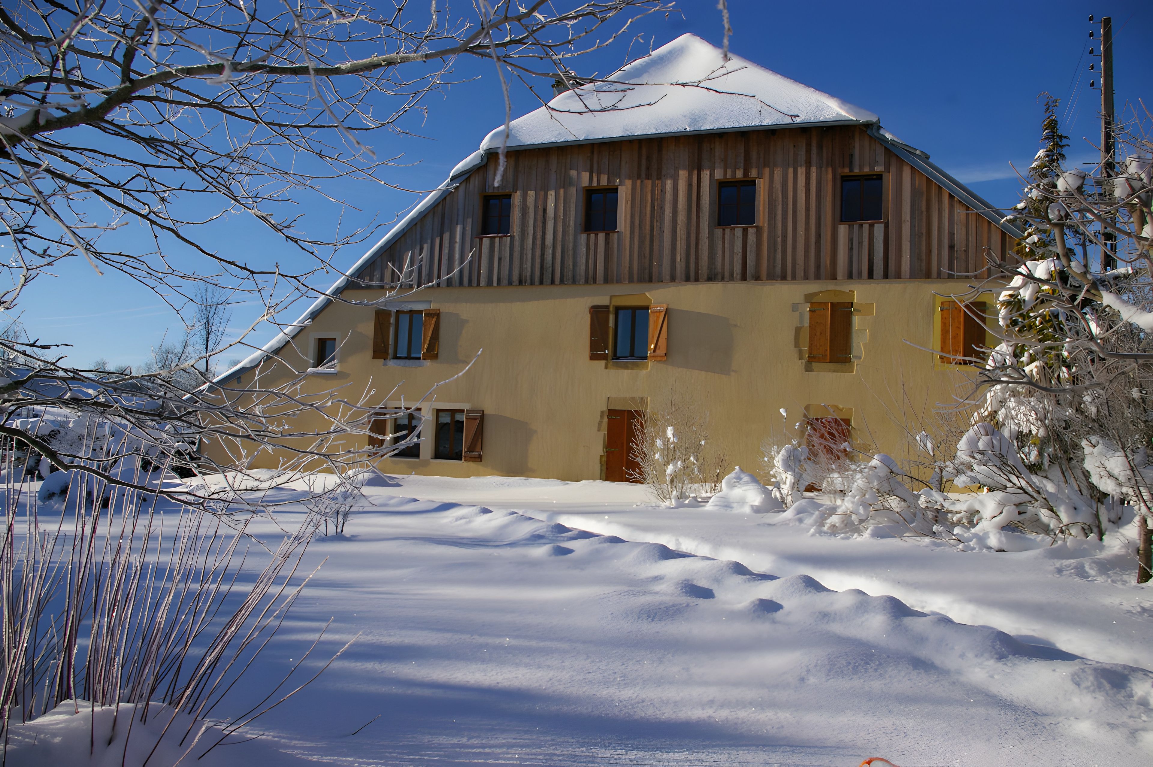 A wooden building with multiple windows and a snow-covered roof.