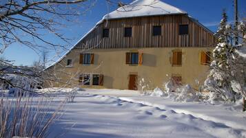 A wooden building with multiple windows and a snow-covered roof.