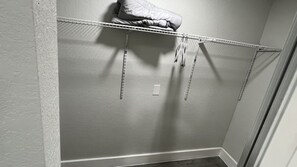 A closet with a metal rod rack and a folded blanket on top. - 5-Bedroom Hollywood Home with AC, Room or Entire House (Hollywood)