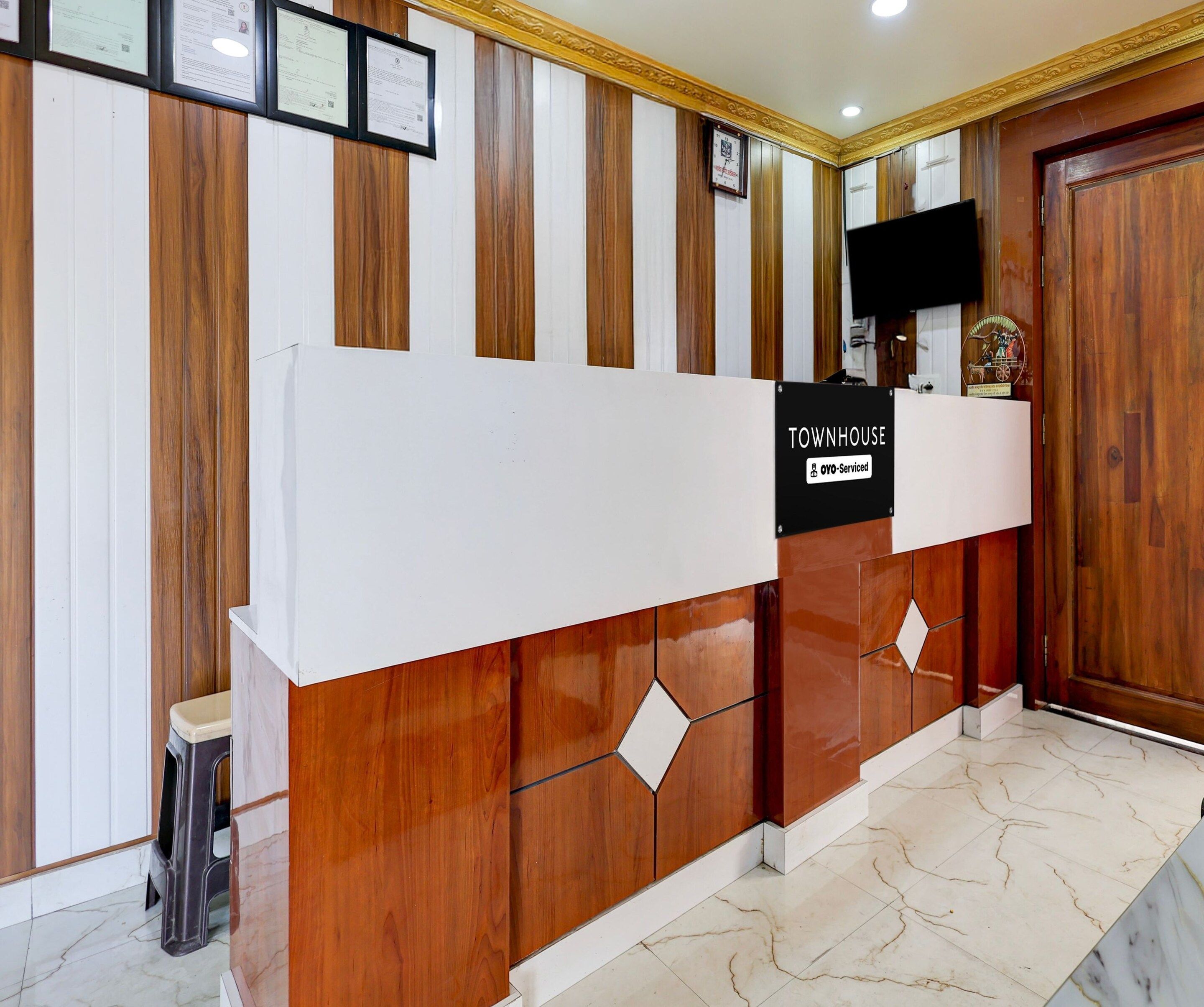 A reception desk with a sign indicating it is serviced by OYO.