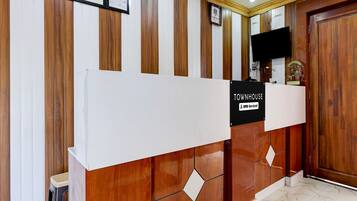 A reception desk with a sign indicating it is serviced by OYO.