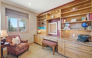 Een studeerkamer met een bureau, stoel, kasten en een wereldbol.