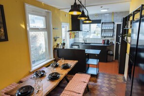 A compact kitchen with a dining area, a bench, and a window. - Cardiff | 4BR | Sleeps 10 | Groups | Contractors (Cardiff)