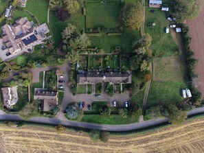 Eine Vogelperspektive eines Wohngebiets mit mehreren Häusern, einem großen Feld und einer Straße.
