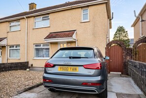 A residential building with a parked car in front. - 4-Bed House Sleeps 8 · Free Parking & Patio · 1 Min to Margam Deer Pub (Neath Port Talbot)