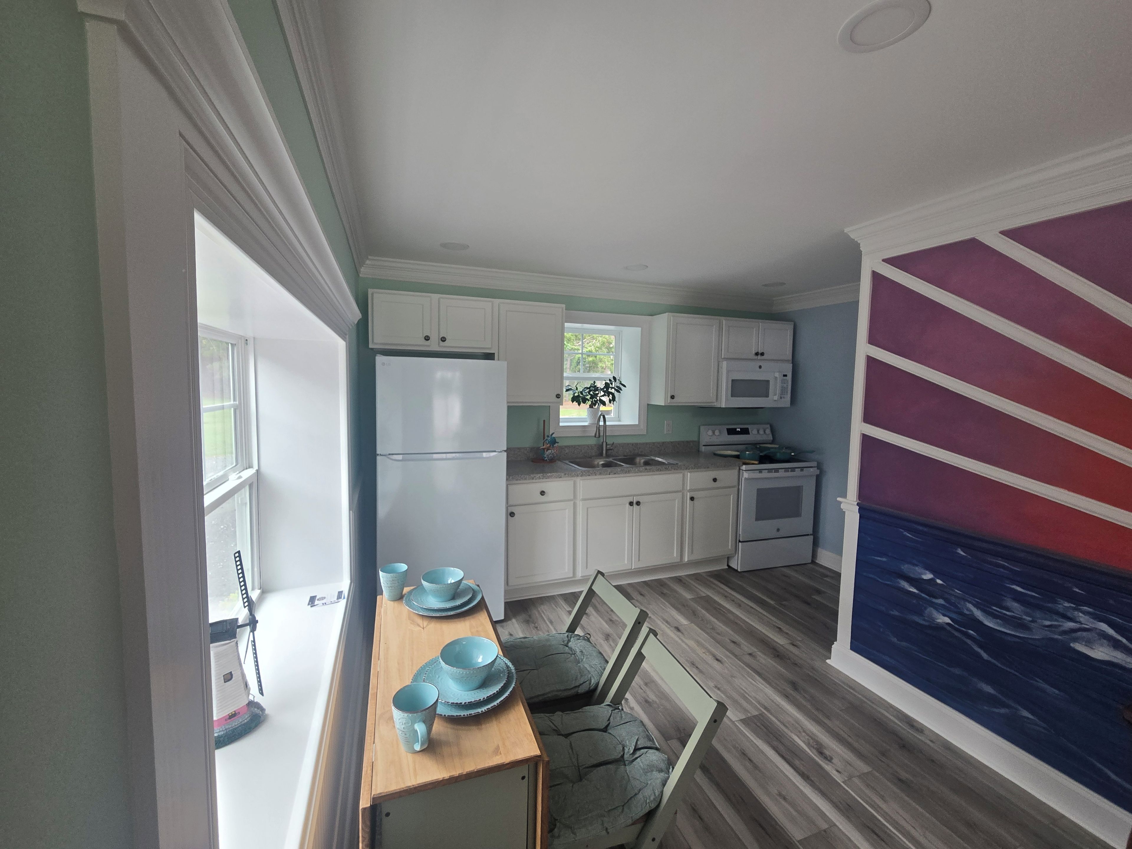 A kitchen with white cabinets, a refrigerator, a microwave, and a stove.