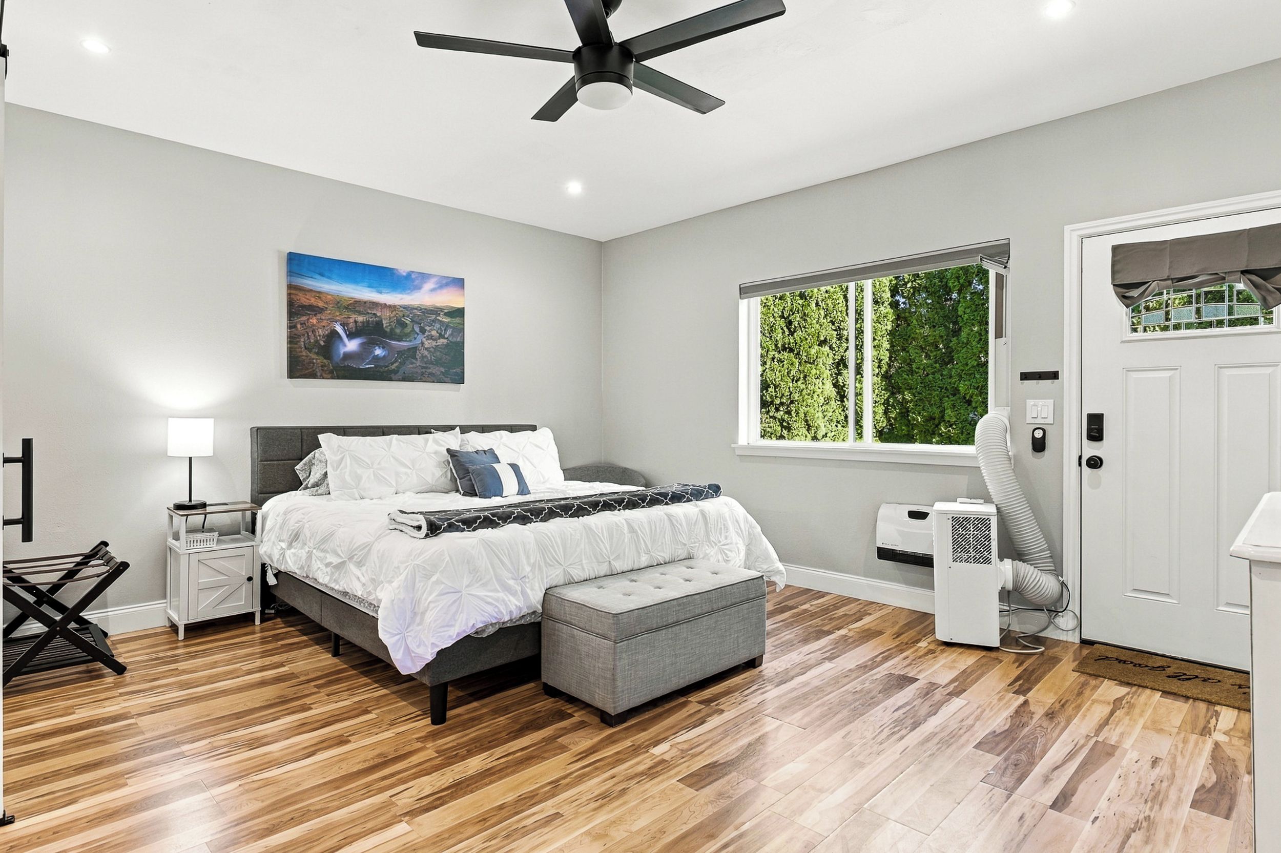 Une chambre à coucher avec un lit, une table de chevet, une lampe et un ventilateur de plafond.
