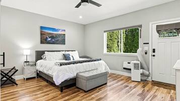 Une chambre à coucher avec un lit, une table de chevet, une lampe et un ventilateur de plafond.