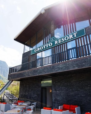 Un edificio con un letrero que dice 'Grotto Resort' y un balcón con mobiliario exterior.