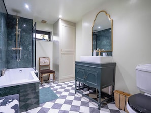 A bathroom with a bathtub, a sink, a mirror, and a toilet. - Foxley Lodge (Norwich)