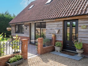 A house with a tiled roof, a brick entrance, and a metal gate. - Foxley Lodge (Norwich)