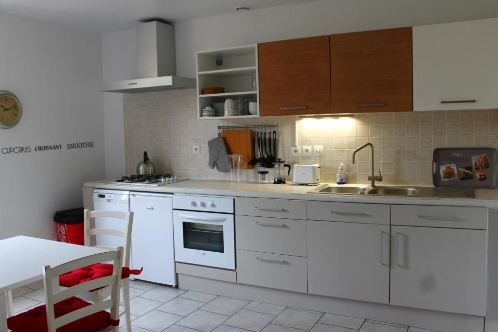 A kitchen with white cabinets, a stove, oven, and a sink.