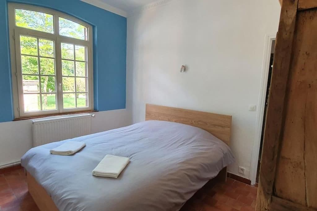 Ein Schlafzimmer mit einem Einzelbett, einem Fenster und einer Heizung.