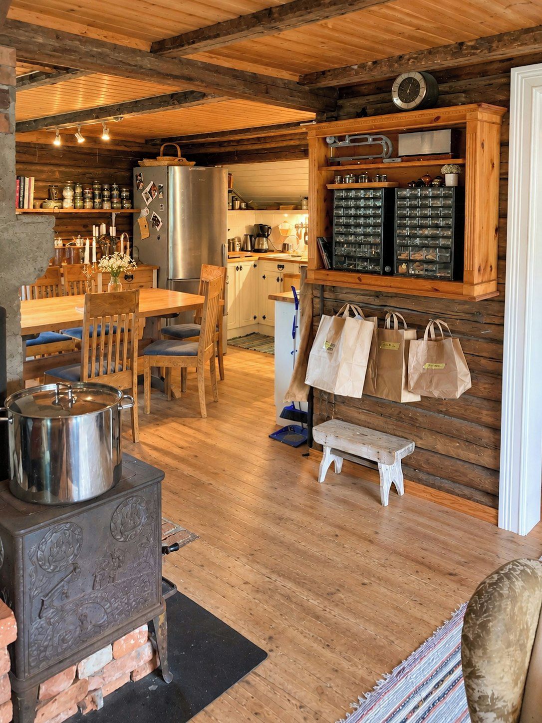 A rustic kitchen with wooden beams, a stove, and a wooden dining table.