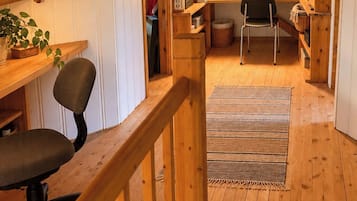 Un intérieur en bois avec un bureau, une chaise et des étagères.