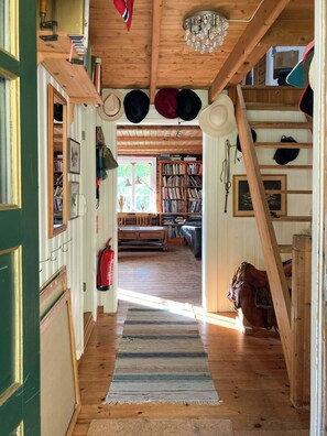 A wooden interior with a staircase, bookshelves, and a fire extinguisher.