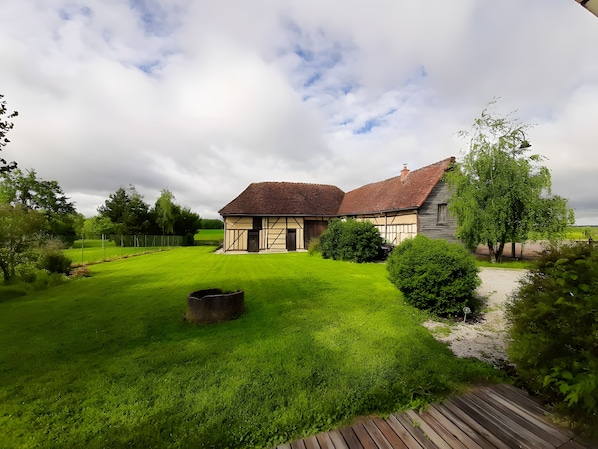 A traditional half-timbered house with a well-maintained lawn and a wooden deck.