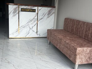 A reception desk with a marble finish and a sign that reads 'RECEPTION'. - Classic Hotel Nitin Inn (Ujjain)