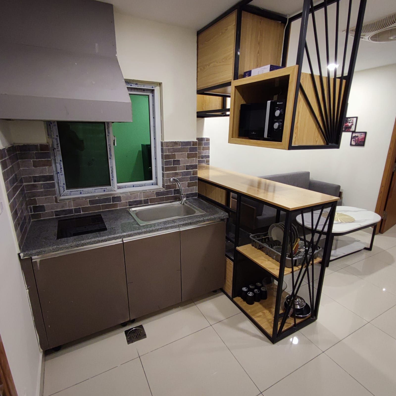 A compact kitchen with a sink, a microwave, and a small dining area with a table and chairs.