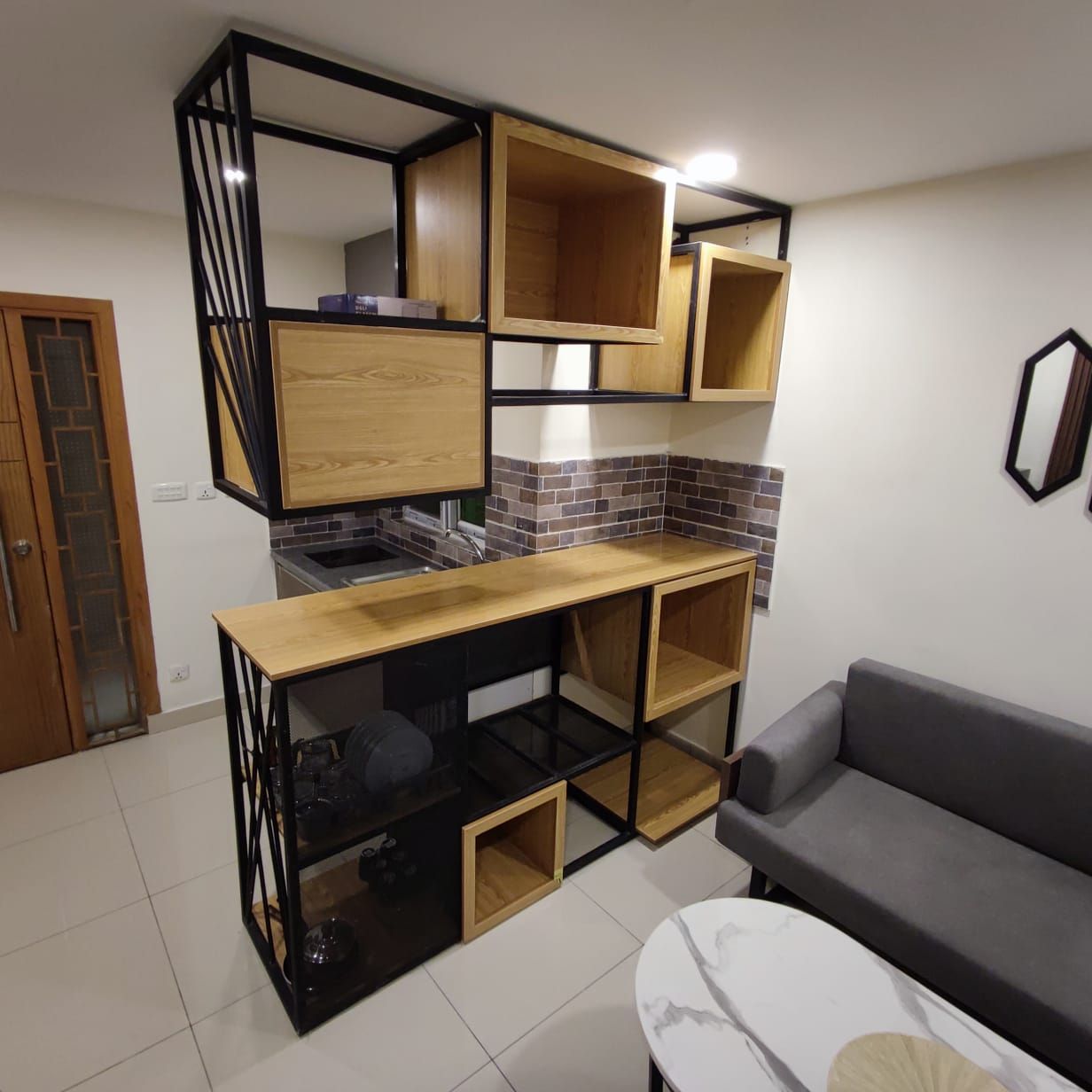 A compact living space with a kitchenette, a dining table, and a sofa.