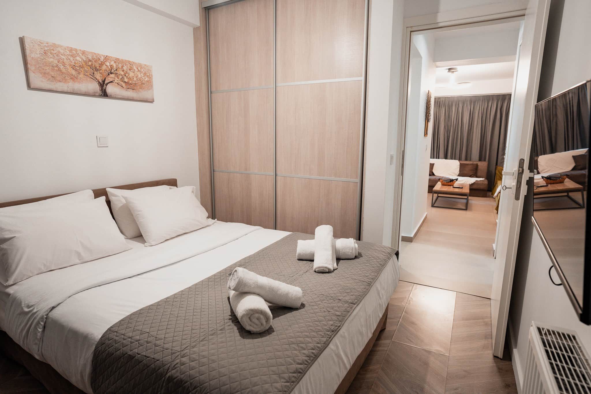 Una camera d'albergo con un letto, un armadio, un quadro appeso e vista sull'area soggiorno.