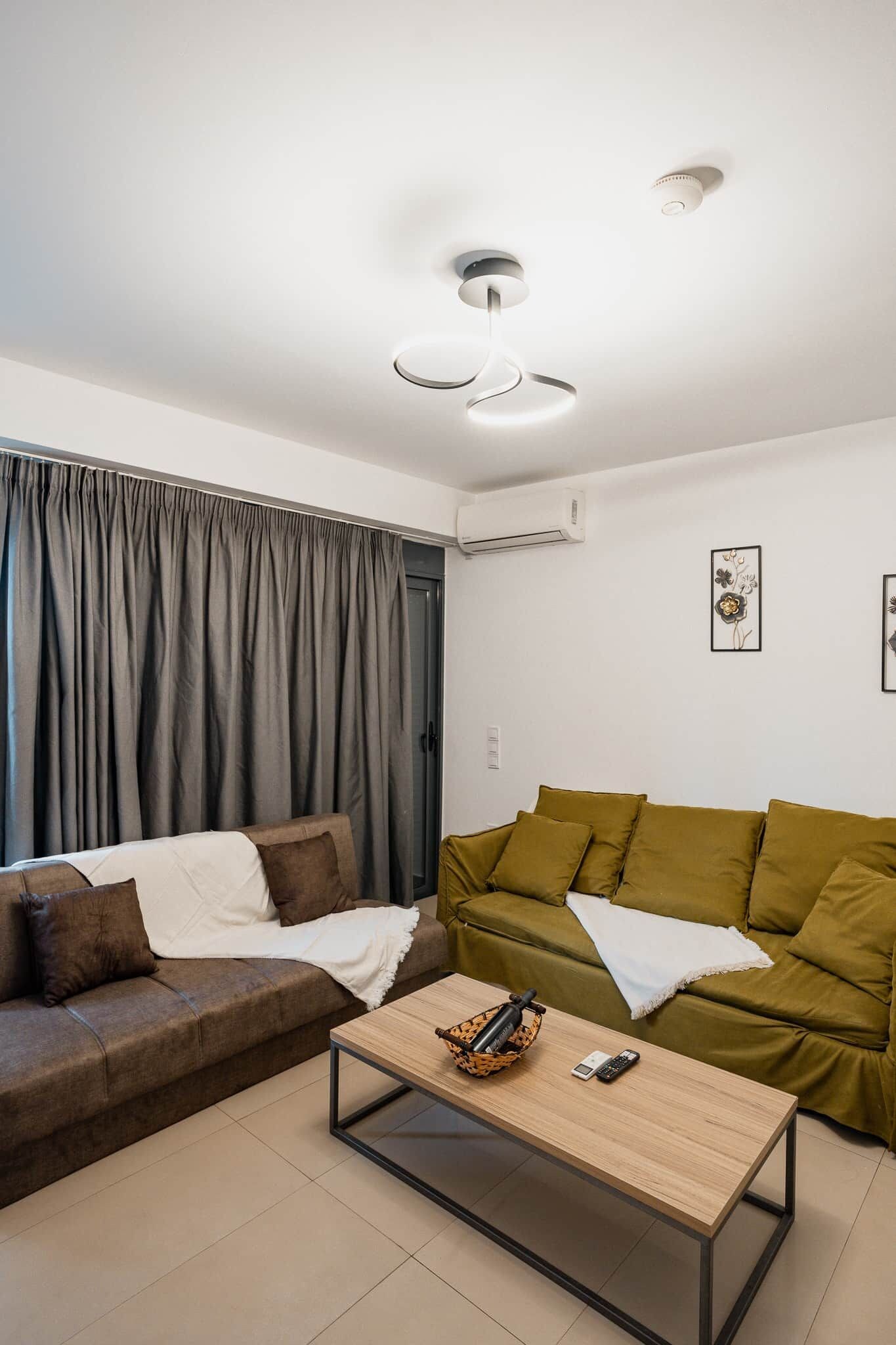 Un soggiorno moderno con due divani, un tavolino e una ventola a soffitto.