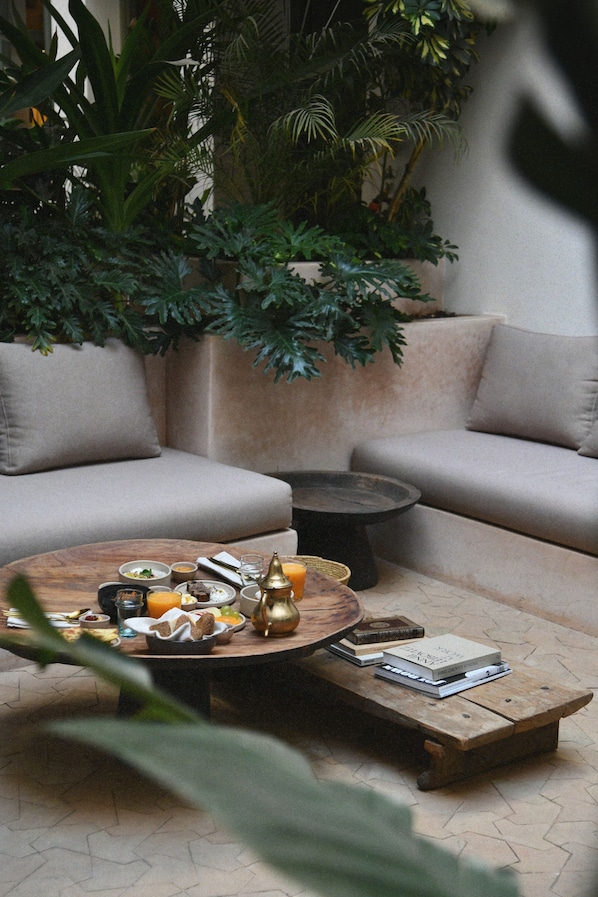 A cozy seating area with a round coffee table, a sofa, and a small side table. - Neighbours Boutique Riad Marrakech (Marrakech)