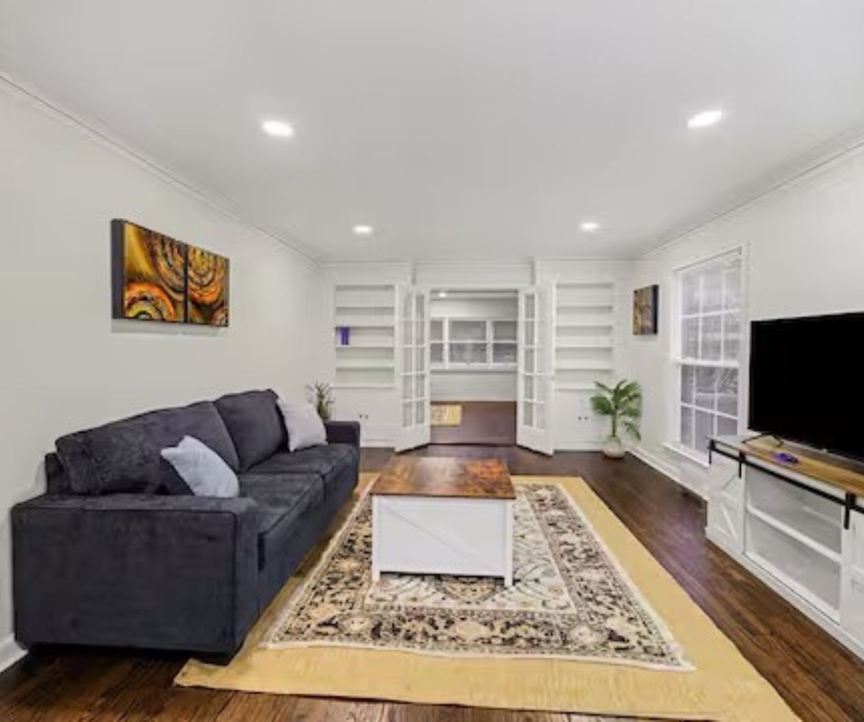 A modern living room with a sofa, coffee table, and TV.