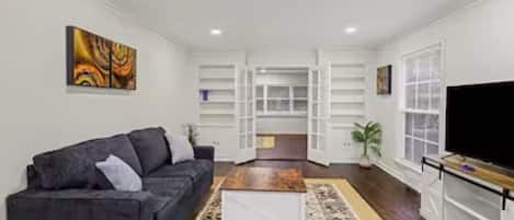 A modern living room with a sofa, coffee table, and TV.