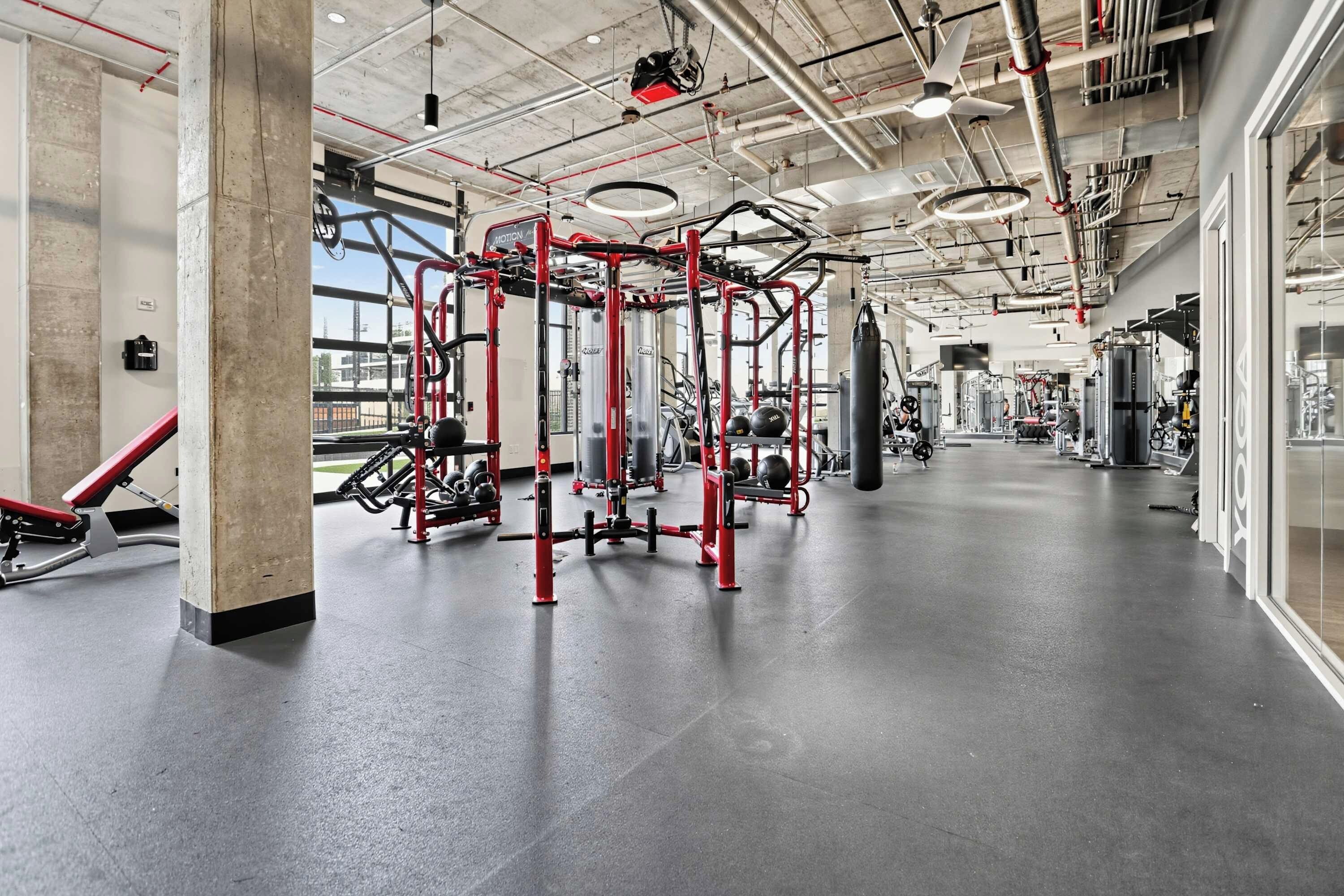 Un gimnasio con equipos de ejercicio variados, incluyendo una barra de dominadas y máquinas de pesas.