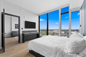 A modern bedroom with a large bed, a flat-screen TV, and a city view. - 45th Floor E11EVEN Skyline & Rooftop Pool (Miami)